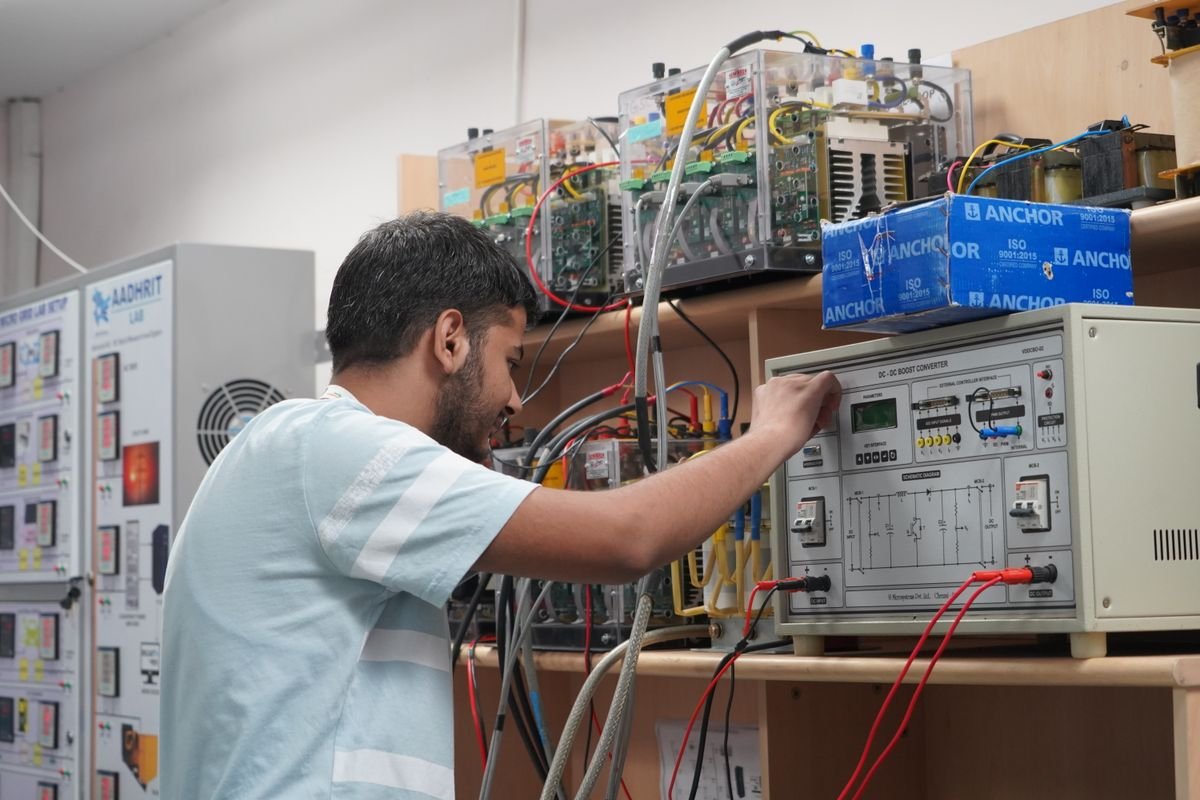 Engineer adjusting electronics and measurement equipment in a research laboratory